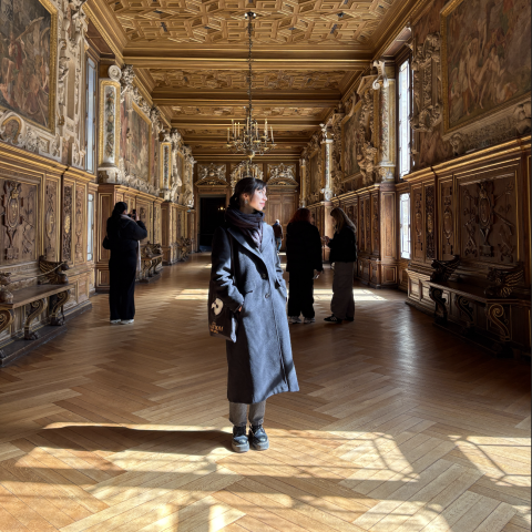 Student in hallway of museum with gold