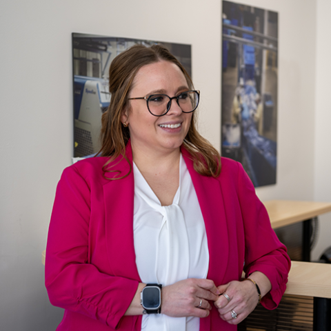 A photo of Emma Sherrie standing in her office.