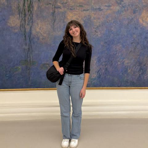 Student in museum standing in front of painting