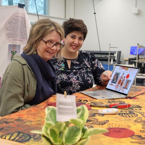 two people looking at fabric pieces