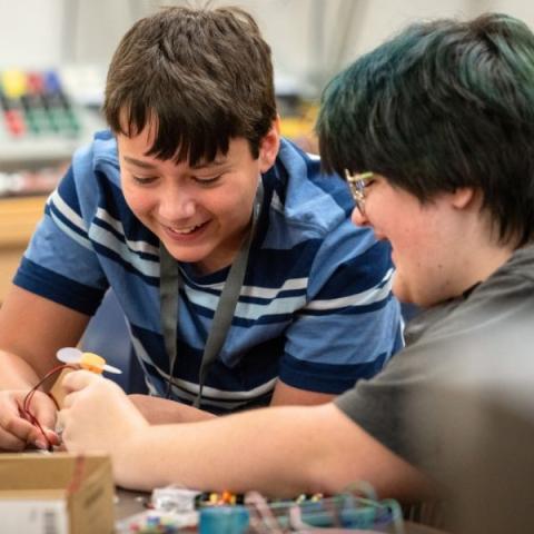 Two young children working on a programmable controller.