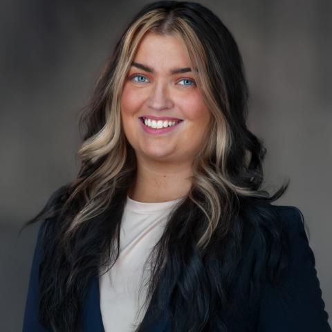 Headshot of Lexus Roshong. She is wearing a white shirt with a black jacket and has shoulder-length dark hair with blonde highlights.