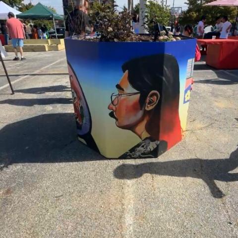 Image of a planter pot with art by Nick Lee on it