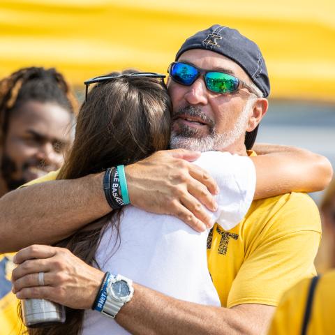 Parent hugging a student at a KSU football game