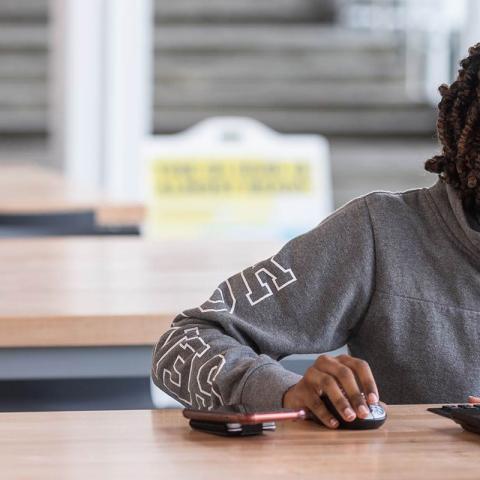 Photo of student by a laptop