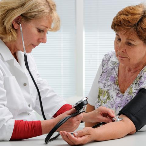 An Adult Gerontology Primary Care Nurse Practitioner takes a geriatric patient's blood pressure