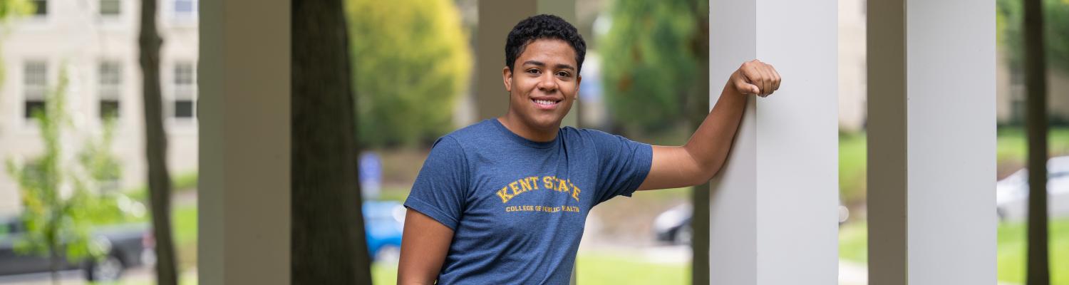 Public Health student stands outside and poses for a picture.