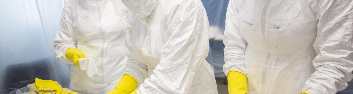 Three technicians in a cleanroom lab
