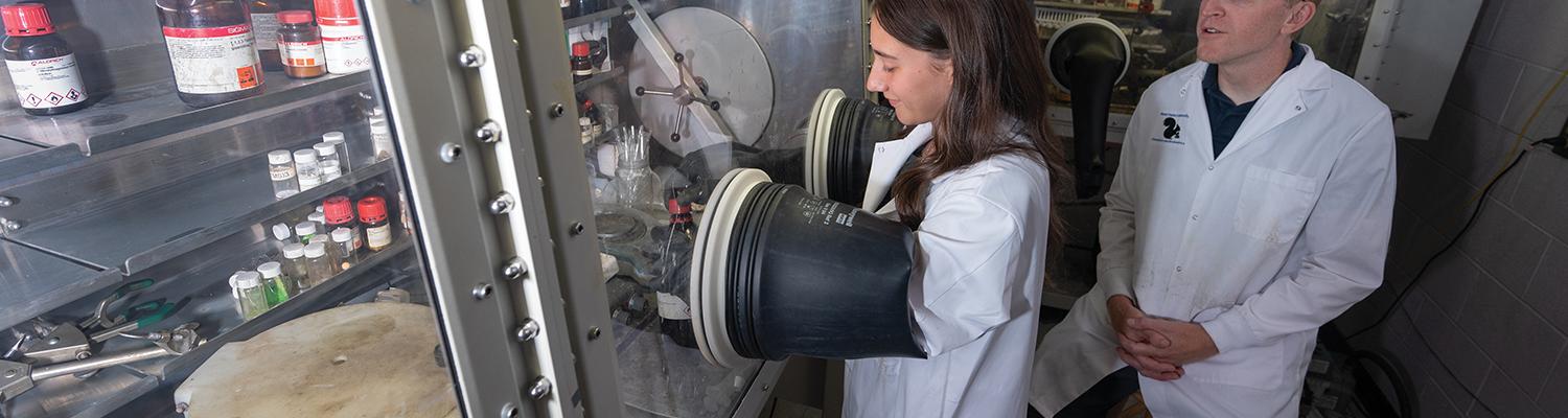 A student and a faculty member conduct research in a lab.