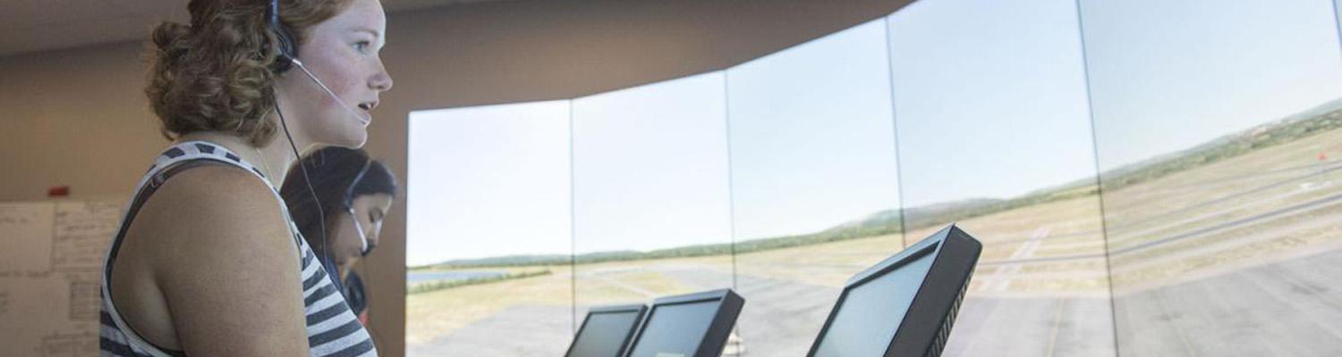 an air traffic student communicates with planes in a tower simulator