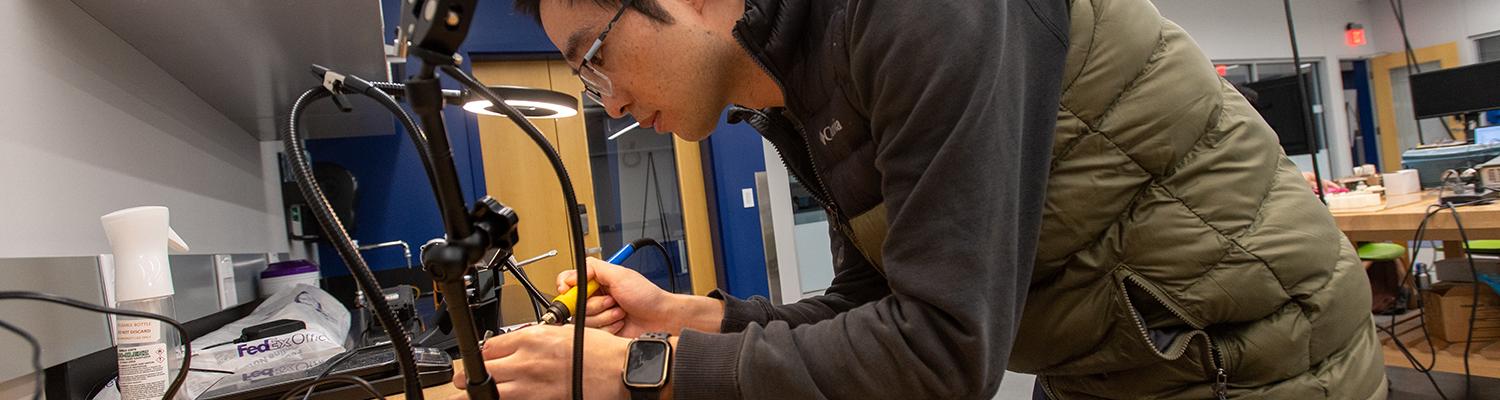 Dr. Tao Shen solders an electrical component at the Advanced Medical Robot Lab