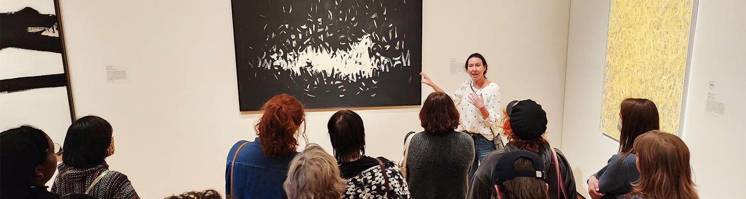 Prof. Shana Klein lecturing on painting in museum to students