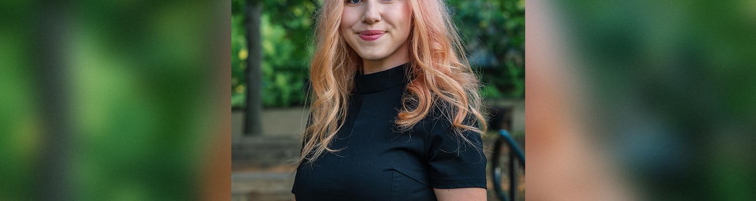 Female student with pink hair among trees