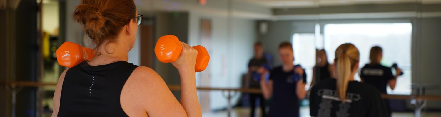 Woman lifting weights in exercise class