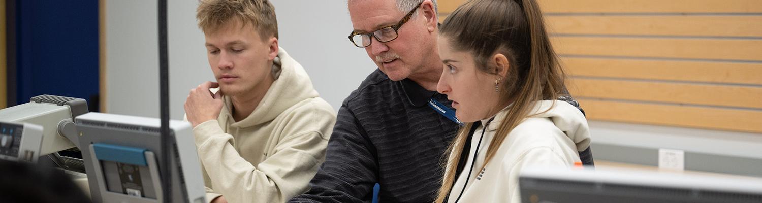 Engineering student and professor examine a circuit readout