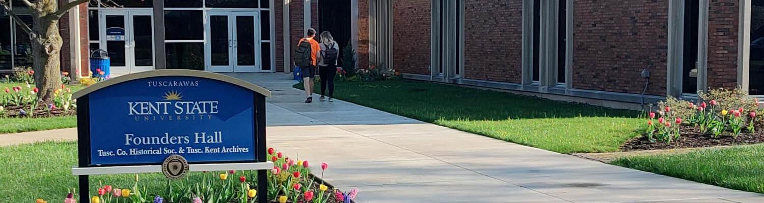 Two students walking towards the enterance of Founders Hall.