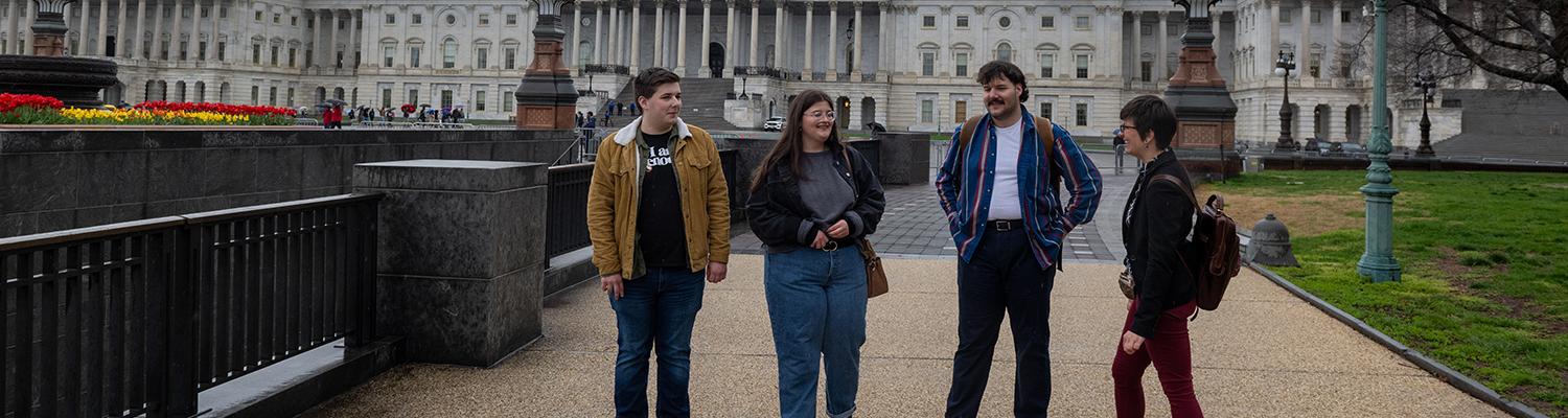 A photo of a group standing in front of the Capitol building