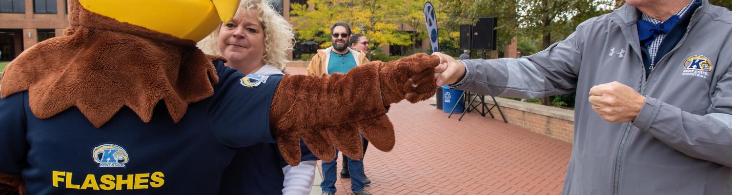 ������ President Todd Diacon fist bumps mascot Flash