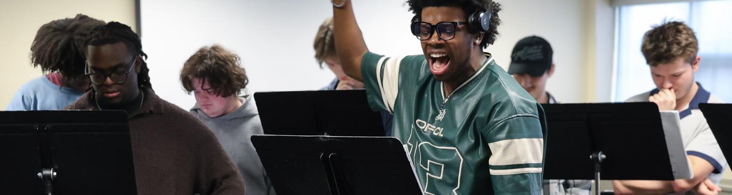 A class of musical theatre students sing along to scores of music
