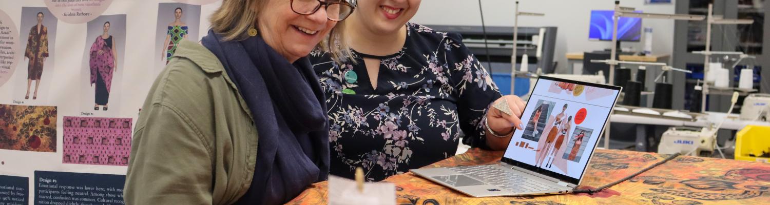 two people looking at fabric pieces