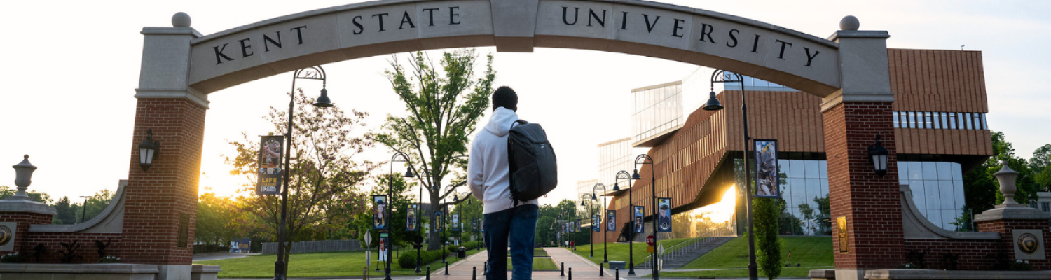 student standing at the arch