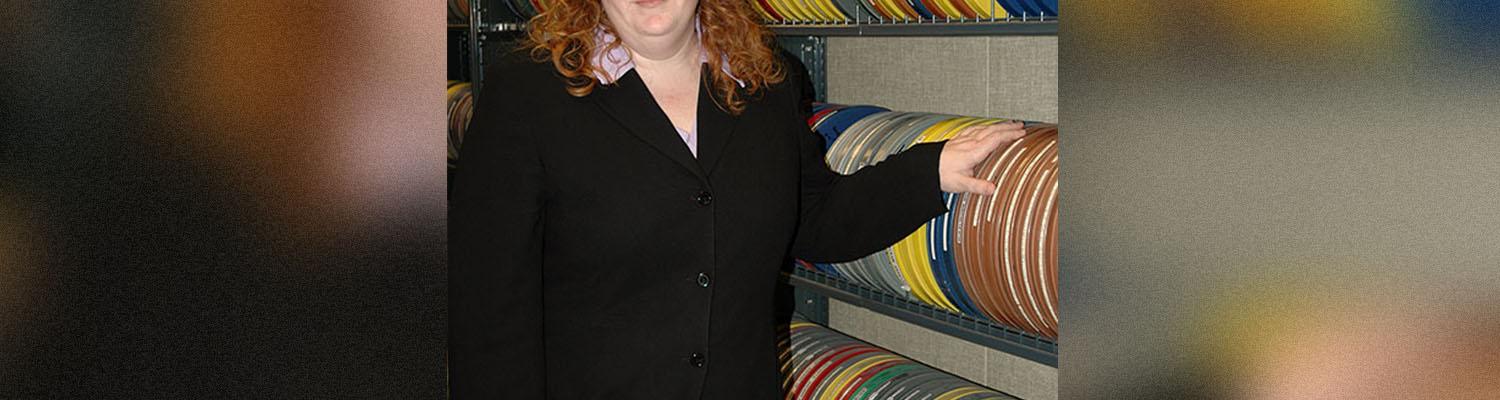 Karen Gracy next to archival film