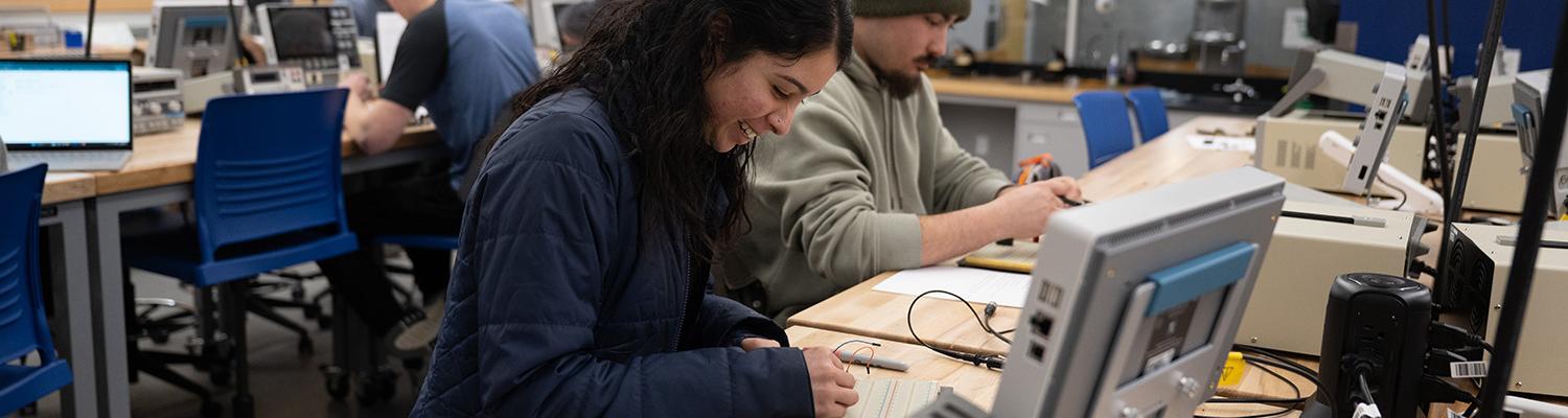 An engineering student creates a project on an electronic circuit board.