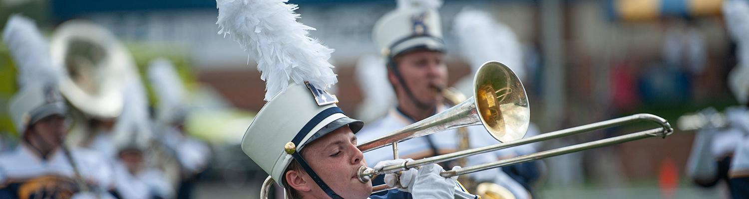 Student in marching band playing the trombone