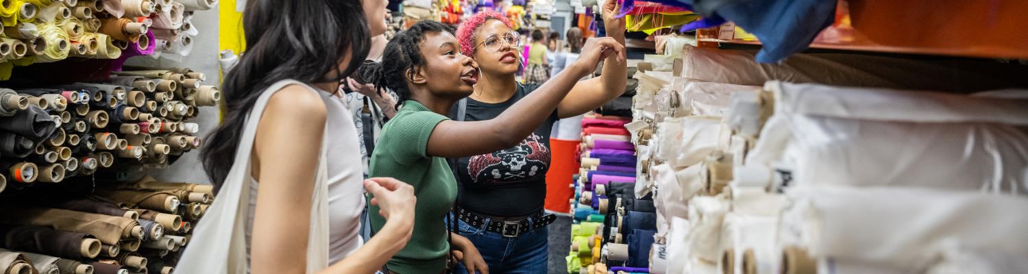 NYC Fashion; students looking at material