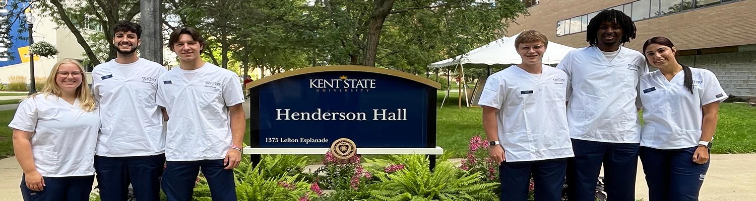 Nursing students standing in a group outside of Henderson Hall on the ������Ƶ campus