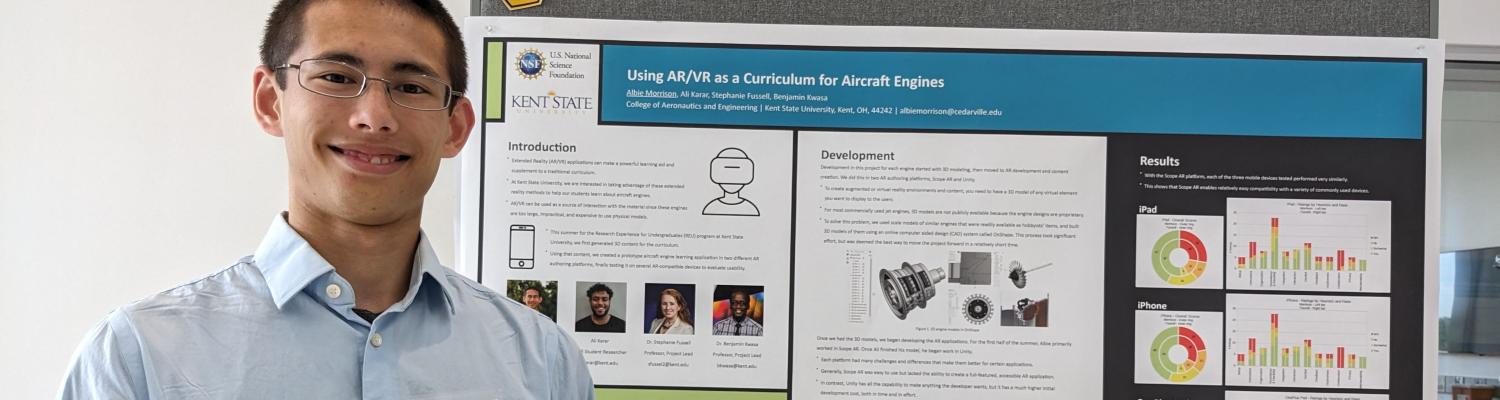 Engineering student Albie Morrison standing next to a poster of his project, "Using AR/VR as a Curriculum for Aircraft Engines."