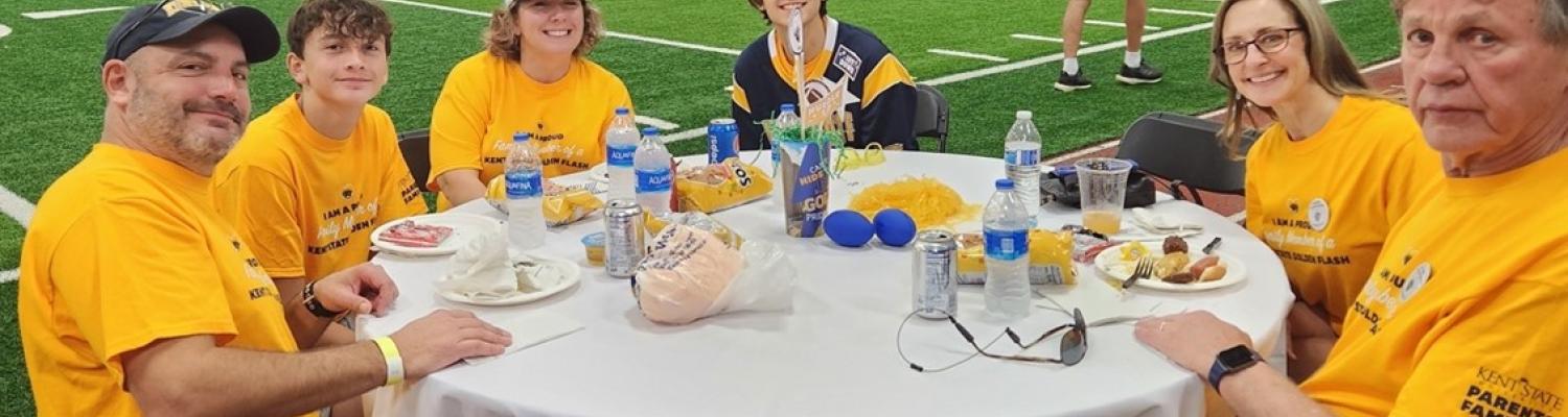 A family celebrates together in the fieldhouse during parents and families appreciation weekend.