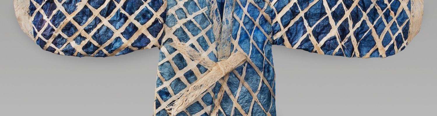 Garment laid out with arms to side; dark blue, light blue colors with a white criss cross pattern. 
