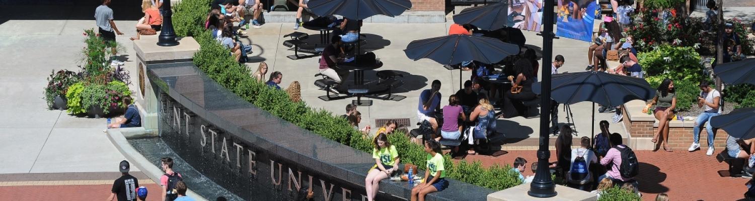 Photo of Kent State's Risman Plaza with students gathered around in the sunshine