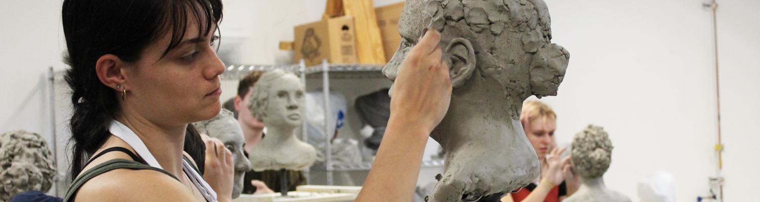 Student working on sculpture bust