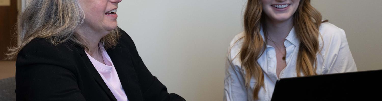 advisor showing something on a computer to a student. 