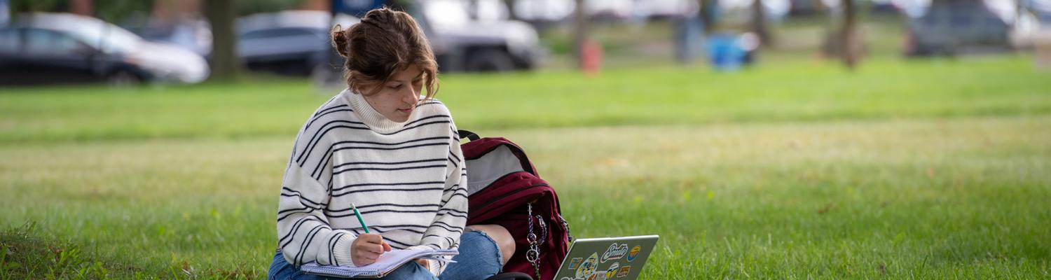 A Kent State Student on the Campus Green Using a Computer