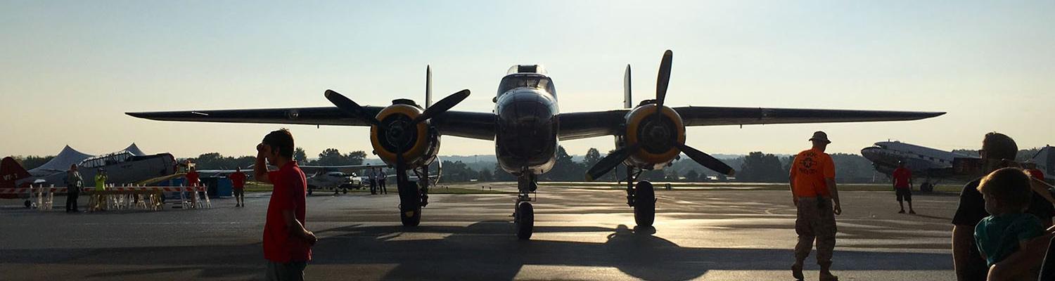 A World War 2 era bomber facing head-on parked on the tarmac at the A&E Expo