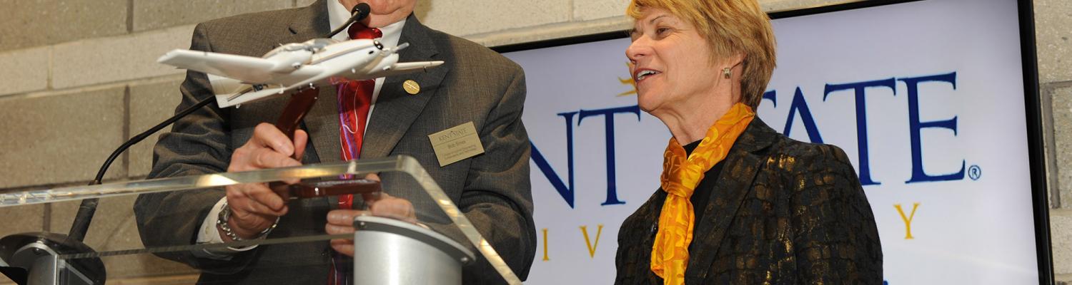 Dean Bob Sines gives a gift to Dr. Beverly Warren during the grand opening of the Aeronautics and Technology building.