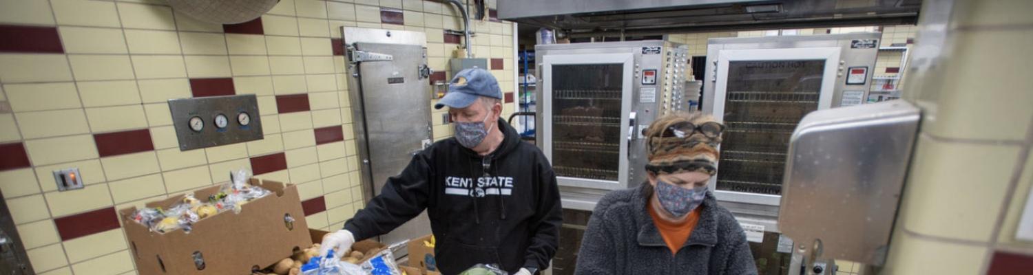 Volunteers Dave and Terri Cardy pack and weigh produce to hand out at the Campus Kitchen in Beall Hall.