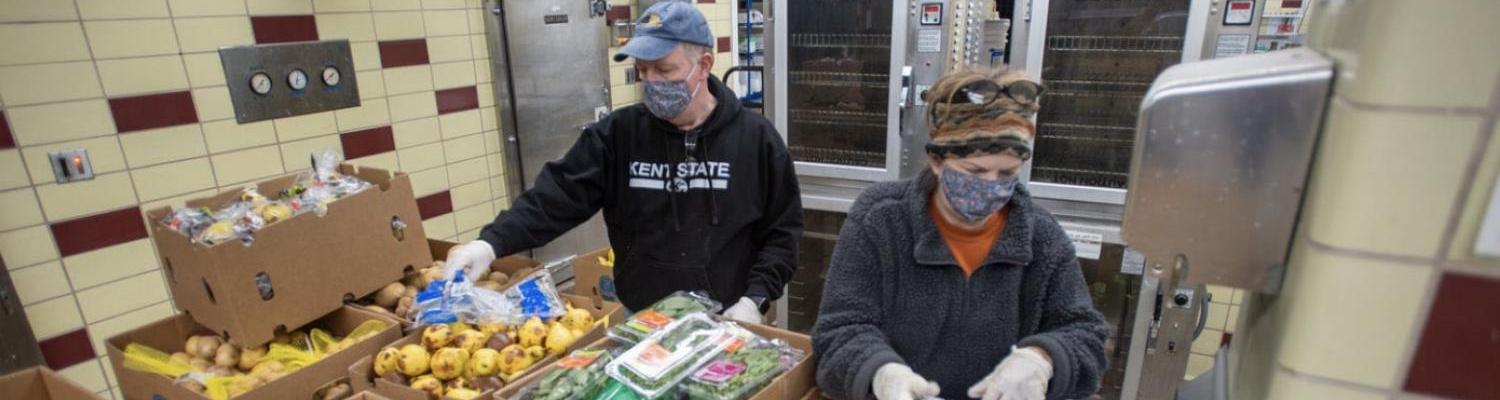 Volunteers Dave and Terri Cardy pack and weigh produce to hand out at the Campus Kitchen in Beall Hall