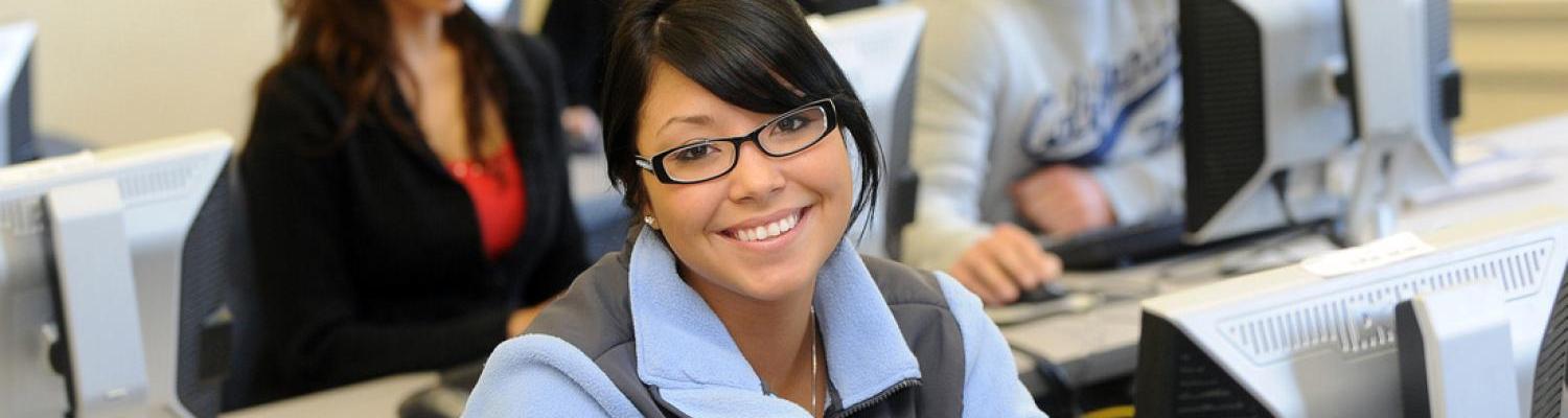 51���� student in a computer lab smiles at the camera