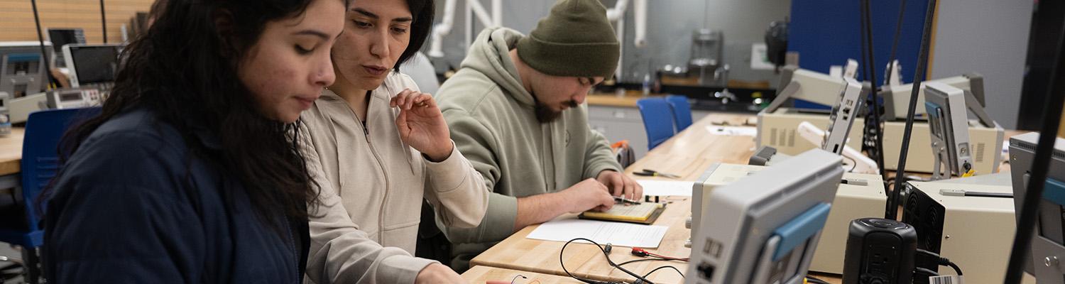 A student works with an instructor to finish an electrical circuit