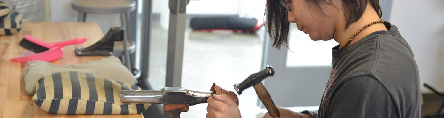 Jewelry/Metals/Enameling student raising a bowl