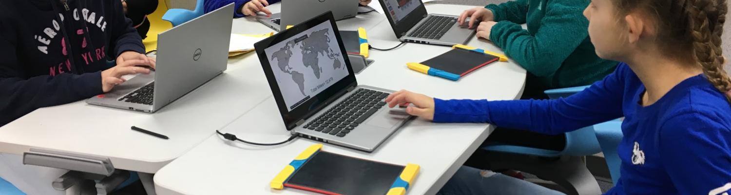Girls and teacher using computers