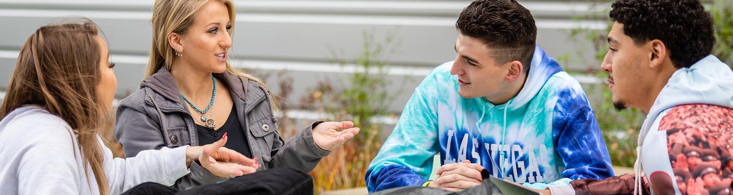 Students sitting at a table outside talking