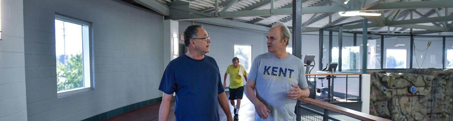Kent State President Todd Diacon walking on the SRWC track with another older patron