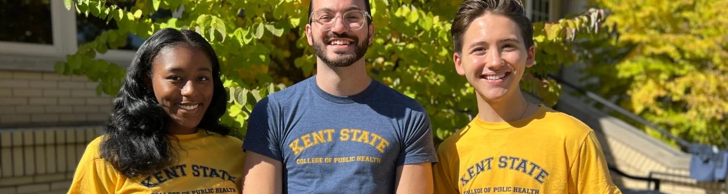 Three students wearing a College of Public Health t-shirt