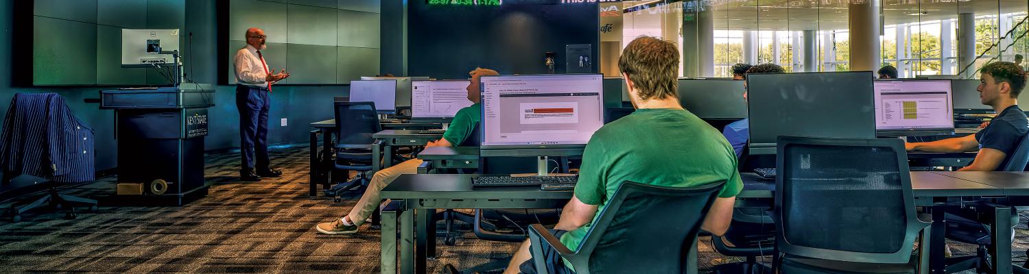 students sitting in finance class in the trading floor classroom.