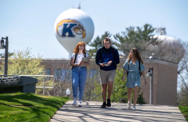 Students walking on campus with the water tower in the background.